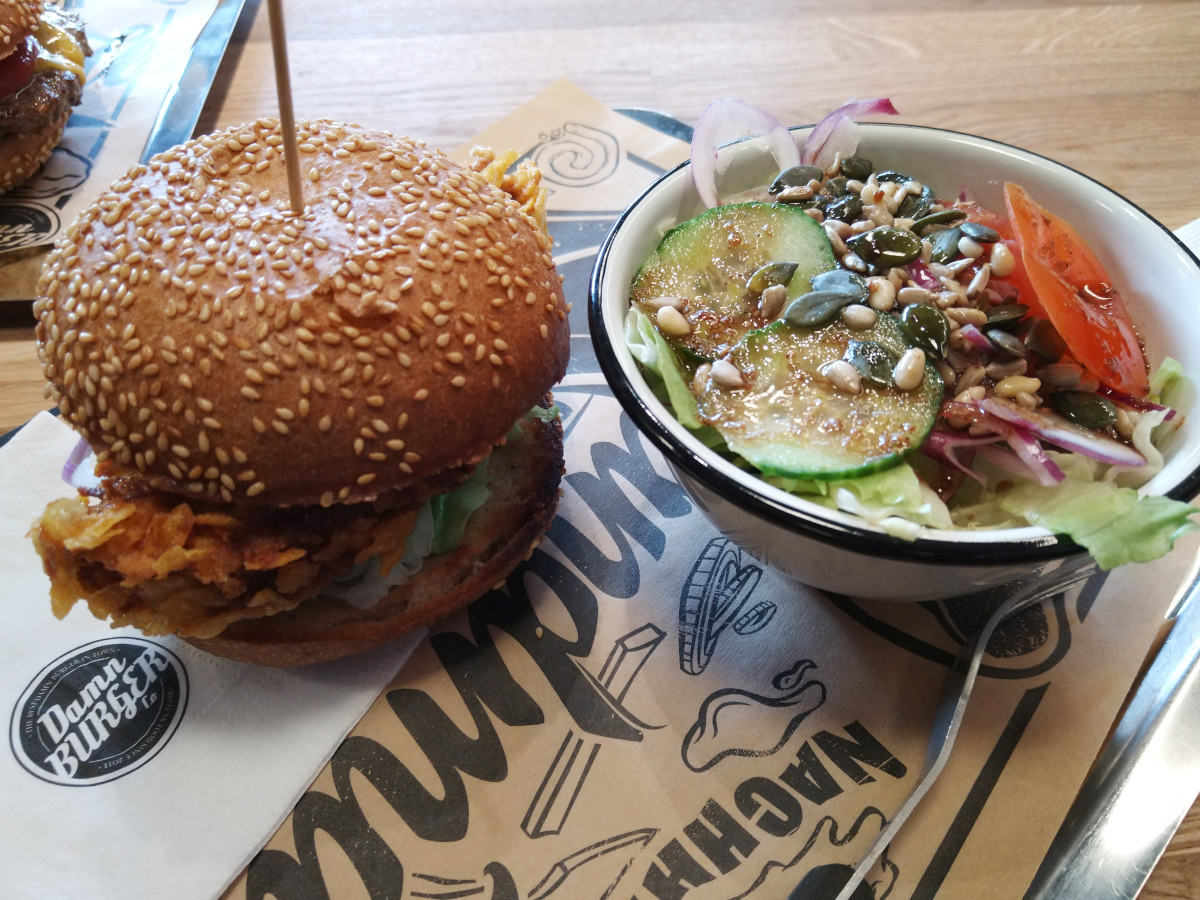 Hähnchen-Burger mit einer Schale Salat.