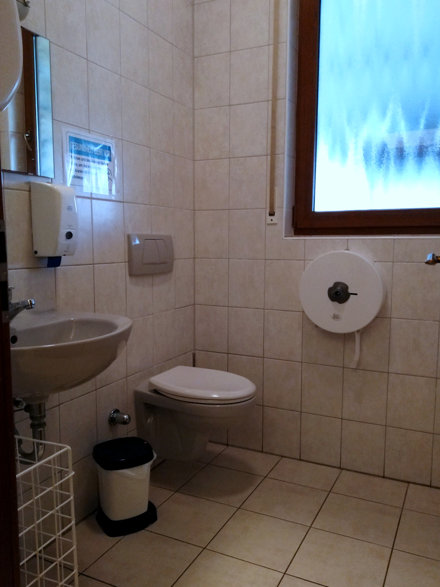 Damen-Toilette. Ein Raum mit Wand-WC und Waschbecken.