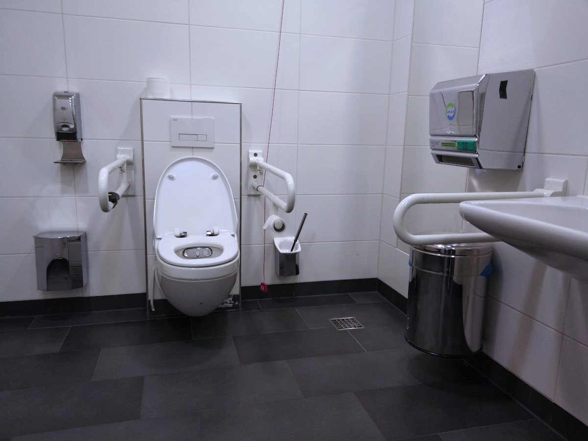 Behinderten-Toilette mit 2 Stütz-Griffen und einer Not-Ruf-Schnur.