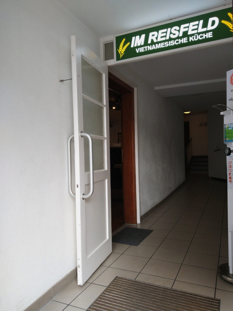 Etwas dunkler Hausflur. Links, direkt nach der Eingangstür, befindet sich die Tür zum Restaurant.