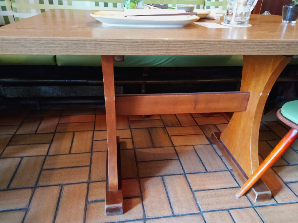 Tisch mit zur Seite gerückten Stühlen, sodass die Tischbeine gut erkennbar sind.