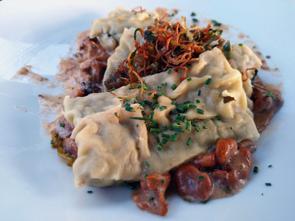 Zwei Maultaschen auf einem Bett aus angebratenen Pfifferlingen mit Pilzsoße.