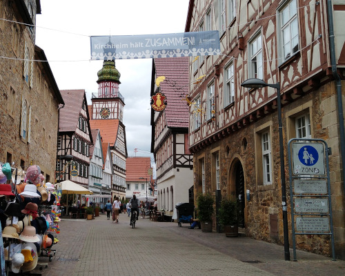 Fußgängerzone in der historischen Altstadt von Kirchheim mit vielen Fachwerkhäusern und einigen Passanten.