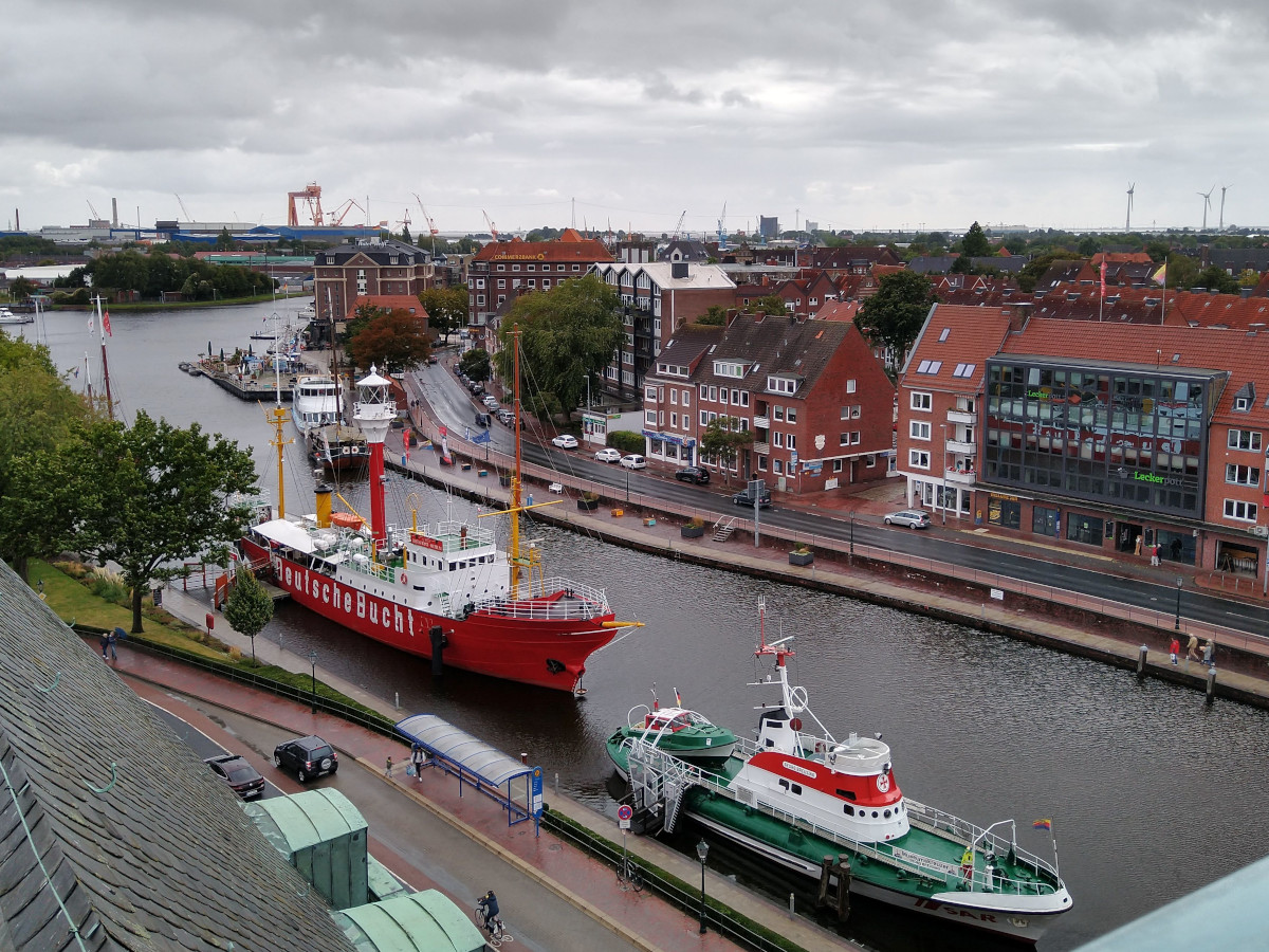 Blick von einem hohen Gebäude auf einen Hafen mit mehreren Schiffen.