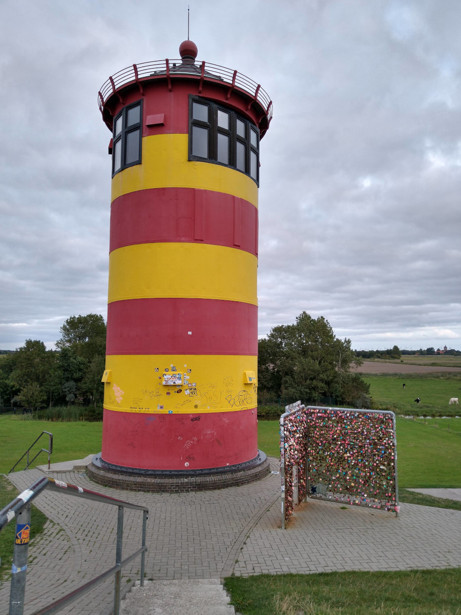 Leuchtturm mit gelben und roten Streifen.
