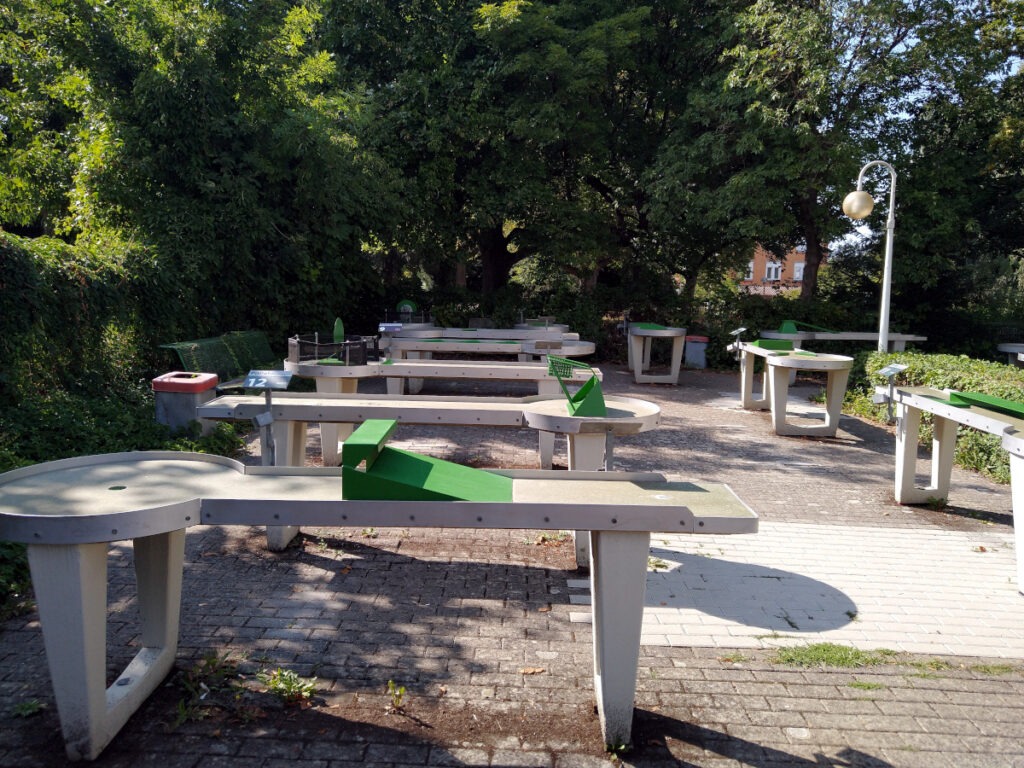 Panorama der verschiedenen PitPat-Bahnen. Die Bahnen verfügen über unterschiedliche Hindernisse, ähnlich wie beim Minigolf, sind jedoch auf Tischen aufgebaut, sodass sie sowohl im Stehen als auch im Rollstuhl gut bespielt werden können.