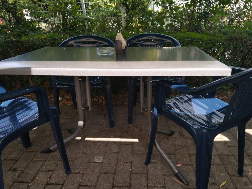 Stühle zur Seite gerückt, sodass die Tischbeine eines Tisches im Sitzbereich des Imbisses gut sichtbar sind.
