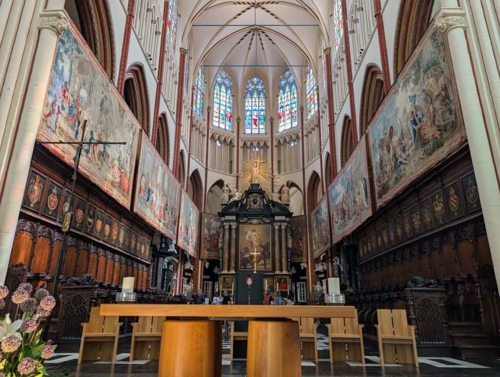 Zentraler einfacher Holzaltar, dahinter größerer Altarraum mit kunstvollem Altartisch und Gemälde von Jesus, beidseitig kunstvoll geschnitzte Bankreihen. Darüber Wandteppiche.